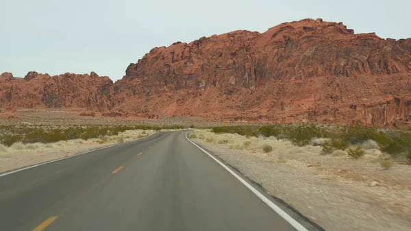 Viaggio in auto nella Valley of Fire, Las Vegas, Nevada, USA. Autostop in viaggio in America, viaggio in autostrada. Formazione rocciosa aliena rossa, deserto del Mojave sembra Marte. Vista dalla macchina — Foto Stock