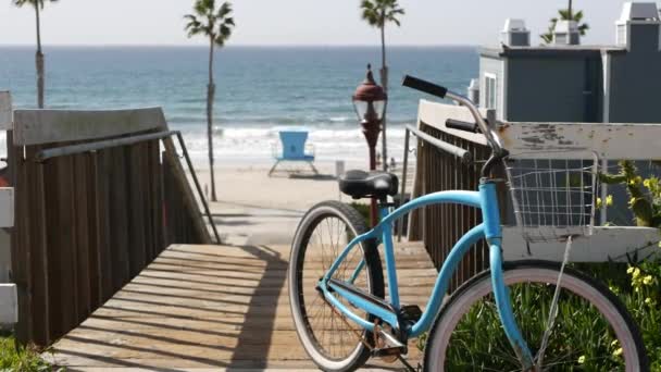 Bicicleta de crucero en bicicleta por la playa del océano, costa de California EE.UU.. Ciclo de verano, escaleras y palmeras. — Vídeo de stock