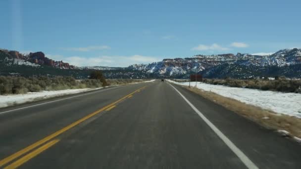 Дорожня поїздка в США від Сіону до Брайс Каньйон, за кермом в Юті. Подорожуючи Америкою, дорога 89 до Діксі Форест. Зимова місцева подорож, спокійна атмосфера і гори. Вид з машини — стокове відео