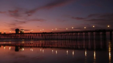 İskele silueti Oceanside California USA. Okyanus gelgiti tropik plaj. Yaz zamanı parlayan atmosfer.