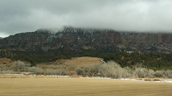 Roadtrip in den USA von Zion zum Bryce Canyon, Autofahren in Utah. Per Anhalter durch Amerika, Route 89 nach Dixie Forest. Winterreise, ruhige Atmosphäre und Schneeberge. Blick aus dem Auto — Stockfoto