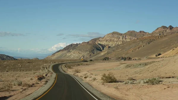 Road trip to Death Valley, Artists Palette drive, California USA. Hitchhiking auto traveling in America. Highway, colorful bare mountains and arid climate wilderness. View from car. Journey to Nevada — Stock Photo, Image