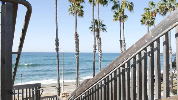 Drewniane schody, dostęp do plaży w Kalifornii. Schody przybrzeżne, fale oceaniczne i palmy. — Zdjęcie stockowe