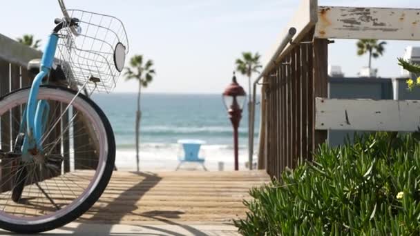 カリフォルニア州海岸の海のビーチで自転車クルーザーバイク。夏のサイクル、階段やヤシの木. — ストック動画