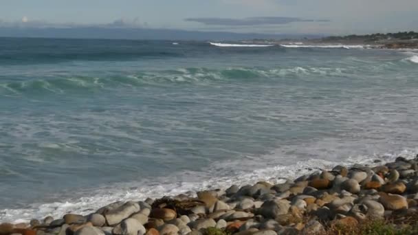 Fale i skały oceaniczne, Monterey, Północna Kalifornia, USA. 17 mil jazdy w pobliżu Big Sur, nadmorskiego golfowego kurortu turystycznego na Pacific Coast Highway. Rozpryskująca się woda i morska bryza żwirowej plaży. Wycieczka — Wideo stockowe