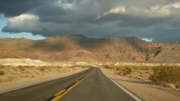 Οδήγηση με αυτοκίνητο από την Κοιλάδα του Θανάτου στο Λας Βέγκας, Νεβάδα ΗΠΑ. Ταξιδεύοντας με ωτοστόπ στην Αμερική. Ταξίδι στον αυτοκινητόδρομο, δραματική ατμόσφαιρα, ηλιοβασίλεμα βουνό και έρημο Mojave. Θέα από αυτοκίνητο — Αρχείο Βίντεο