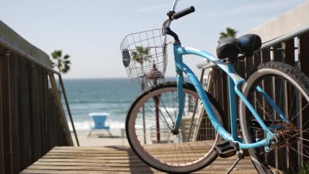 Bicicleta de crucero en bicicleta por la playa del océano, costa de California EE.UU.. Ciclo de verano, escaleras y palmeras. — Vídeo de stock