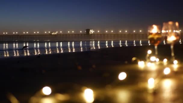 Lampu lilin di kaca, romantis tanggal pantai oleh gelombang laut, laut musim panas. Lilin di atas pasir.. — Stok Video