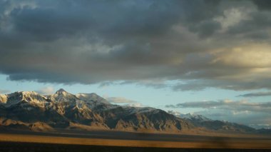 Ölüm Vadisi 'nden Las Vegas, Nevada' ya arabayla yolculuk. Amerika 'da otostop çekmek. Otoyol yolculuğu, dramatik atmosfer, günbatımı dağı ve Mojave çölleri. Arabadan görüntüle
