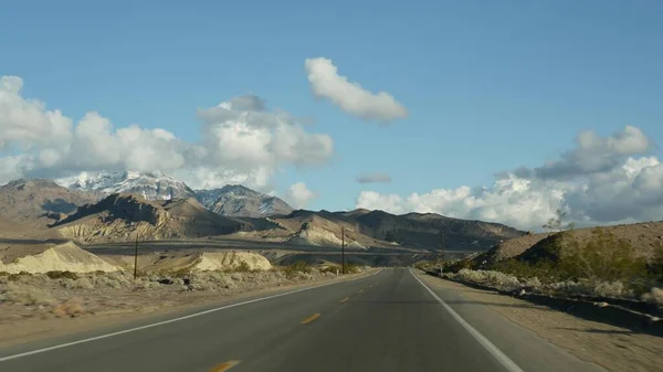 Road trip, bilkörning från Death Valley till Las Vegas, Nevada USA. Jag liftar i Amerika. Highway resa, dramatisk atmosfär, moln, berg och Mojaveöknen. Utsikt från bilen — Stockfoto