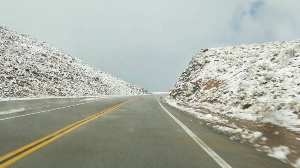 Roadtrip ins Death Valley, Autofahren, Schnee in Kalifornien, USA. Per Anhalter durch den Winter in Amerika. Autobahn, Gebirgspass und trockene karge Wildnis. Beifahrer aus dem Auto. Reise nach Nevada — Stockfoto