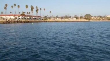 Yelkenli tekne ya da yattan deniz suyunun gün batımı manzarası, okyanus kıyısı, Kaliforniya 'da yaz tatili. Limanda şehir tabelası, yat limanında kısa mektuplar. Pasifik Okyanusu kıyısı, balina izleme turu.