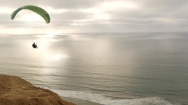 San Diego, Kaliforniya ABD - 22 Kasım 2020 İnsanlar yamaç paraşütü, Torrey Pines uçurumu veya blöf. Paraglider gökyüzünde süzülüyor, uçuyor ya da süzülüyor, paraşüt, uçurtma ya da kanat. Eğlence amaçlı spor hobisi. Okyanus kıyısı