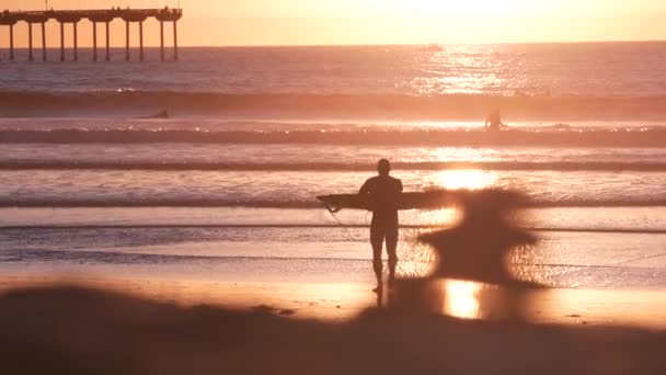 美国加利福尼亚州圣地亚哥 2020年11月28日 日落时 人们在海滨码头的大堆上冲浪 冲浪者在海浪冲浪板上冲浪 在太平洋海岸或海岸度假 娱乐性体育爱好 — 图库视频影像