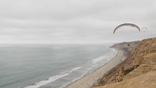 カリフォルニア州サンディエゴ 11月2020パラグライダー トーリーパインズ崖や崖 空の空気 飛行や滑空 パラシュート カイトや翼で上昇パラグライダー レクリエーションスポーツ趣味 大洋岸 — ストック動画