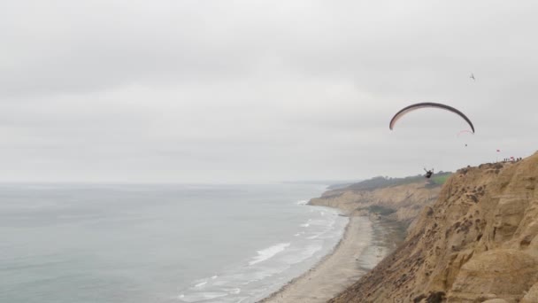 カリフォルニア州サンディエゴ 11月2020パラグライダー トーリーパインズ崖や崖 空の空気 飛行や滑空 パラシュート カイトや翼で上昇パラグライダー レクリエーションスポーツ趣味 大洋岸 — ストック動画