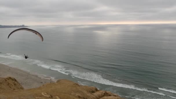 美国加利福尼亚州圣地亚哥 2020年11月22日人们滑翔伞 托里松树悬崖或虚张声势 滑翔机在空中飞行 飞行或滑翔 降落伞 风筝或机翼 娱乐性体育爱好 海洋海岸 — 图库视频影像