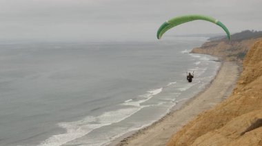 San Diego, Kaliforniya ABD - 22 Kasım 2020 İnsanlar yamaç paraşütü, Torrey Pines uçurumu veya blöf. Paraglider gökyüzünde süzülüyor, uçuyor ya da süzülüyor, paraşüt, uçurtma ya da kanat. Eğlence amaçlı spor hobisi. Okyanus kıyısı