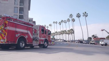 La Jolla, Kaliforniya ABD - 23 Kasım 2020: Kırmızı itfaiyeciler itfaiye aracı, acil cankurtaran aracı veya 911 itfaiye aracı San Diego 'da. İtfaiyecilerin, can yeleklerinin ve palmiye ağaçlarının olduğu kamu güvenliği arabası..