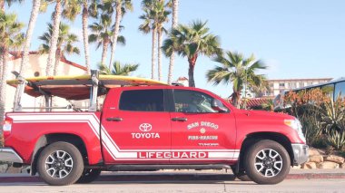 La Jolla, California USA - 23 Kasım 2020: cankurtaran kırmızı kamyonet, sahil kenarında can kurtaran. Sörf güvenliği için kıyıdan bir kurtarma aracı, 911 aracı. San Diego caddesinde palmiye ağacı