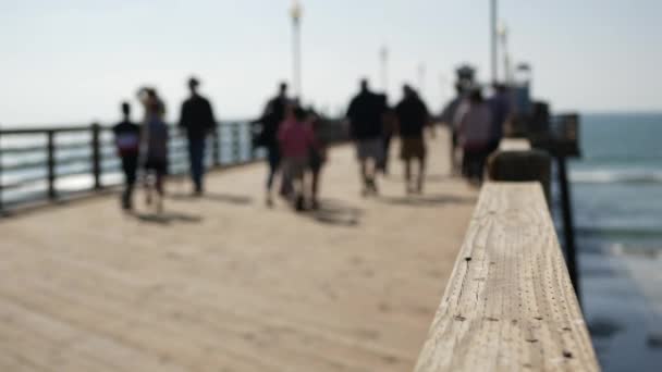 Muelle de madera paseo marítimo, California playa EE.UU.. Océano desenfocado, olas marinas. Gente caminando. — Vídeo de stock