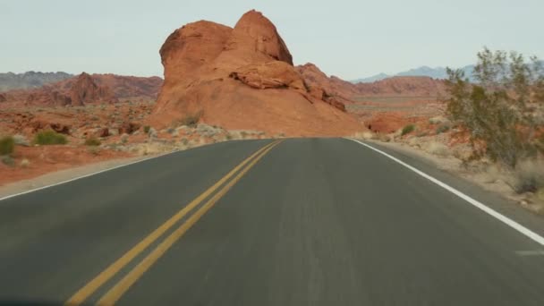 Roadtrip, Autofahren in Valley of Fire, Las Vegas, Nevada, USA. Per Anhalter in Amerika unterwegs, Autobahnfahrt. Rote außerirdische Felsformation, Wüste Mojave sieht aus wie Mars. Blick aus dem Auto — Stockvideo