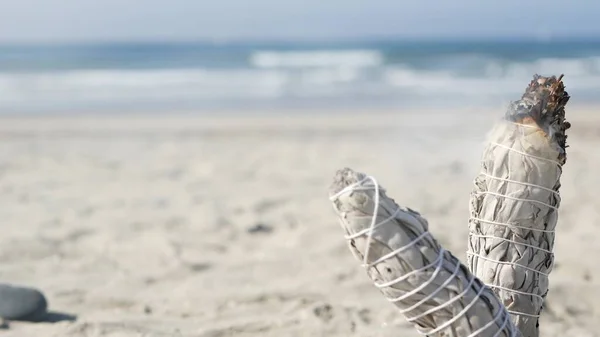 Humo de salvia blanca, quemadura de palo de mancha. Meditación de manchas de aroma en la playa del océano, olas de agua de mar. — Foto de Stock