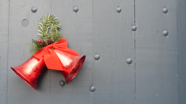 Decoración de Navidad y Año Nuevo, pino o abeto, cinta roja y campanas en la puerta o puerta. — Vídeo de stock