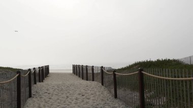 Tahta çit, kumlu plaj, California USA. Pasifik Okyanusu kıyıları, denizin sisi....