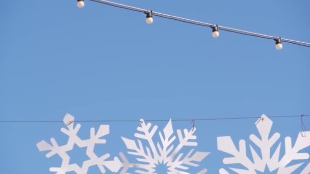 Kunstmatige kartonnen sneeuwvlokken, straatdecor voor Kerstmis en Gelukkig Nieuwjaar. — Stockvideo