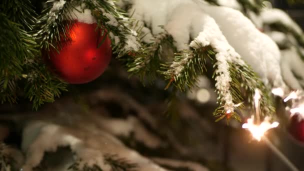 Sparkler fuegos artificiales quema, árbol de Navidad en la nieve, Año Nuevo o Navidad bengala luz — Vídeos de Stock