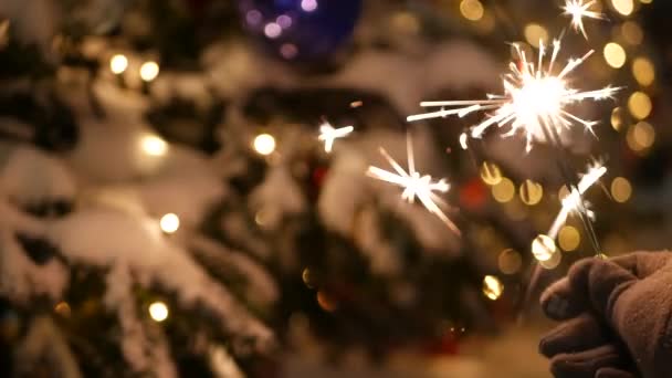 Sparkler fyrverkeri brinnande, julgran i snö, nyår eller jul bengaliska ljus — Stockvideo