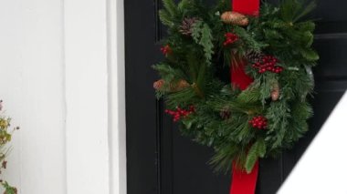 Çam ağacından ya da köknar ve kırmızı kurdeleli yeşil Noel çelengi..