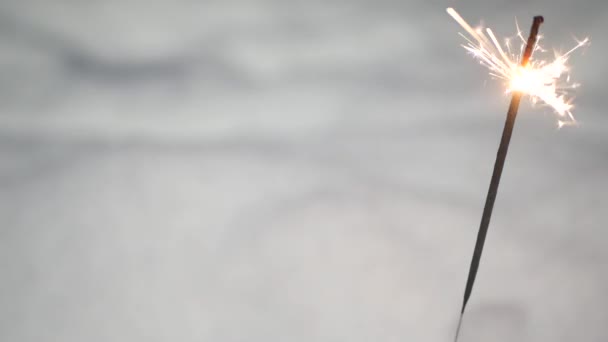 Сверкающий фейерверк горит в снегу, новогодние бенгальские огни. Снежинки. — стоковое видео