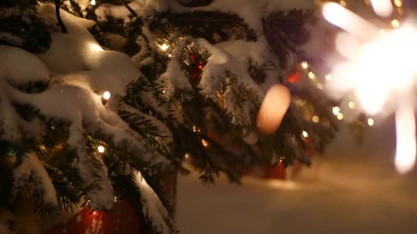 Árbol de Navidad en la nieve, fuegos artificiales chispeantes quema, Año Nuevo o Navidad bengala luz — Vídeo de stock