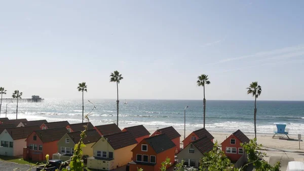 Cottages in Oceanside California USA. Beachfront bungalows. Ocean beach palm trees. Lifeguard tower. — Stock Photo, Image