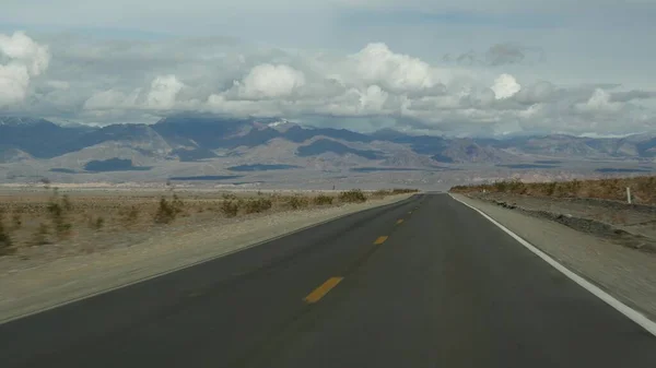 Road trip to Death Valley, driving auto in California, USA. Hitchhiking traveling in America. Highway, mountains and dry desert, arid climate wilderness. Passenger POV from car. Journey to Nevada — Stock Photo, Image