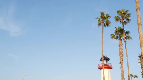Маяк, пальми і блакитне небо. Червоний і білий маяк. Село на березі моря. Каліфорнія США — стокове фото