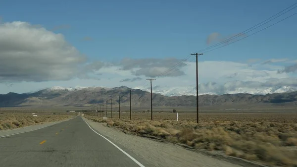 Wycieczka do Doliny Śmierci, jazda samochodem w Kalifornii, USA. Podróżując autostopem po Ameryce. Autostrada, góry i sucha pustynia, suchy klimat pustynia. Pasażerski POV z samochodu. Podróż do Nevady — Zdjęcie stockowe