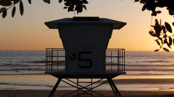 Lifeguard watch tower sunny sunset beach. Watchtower hut, pacific ocean coast. California summertime