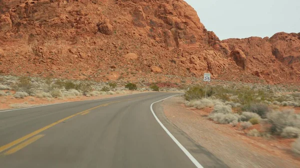 Podróż samochodem w Dolinie Ognia, Las Vegas, Nevada, USA. Podróże autostopem po Ameryce, podróż autostradą. Formacja czerwonych skał obcych, pustynna pustynia Mojave wygląda jak Mars. Widok z samochodu — Zdjęcie stockowe