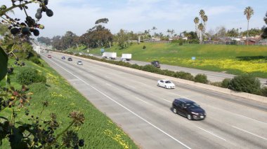 Arabalar eyaletler arası Kaliforniya otoyolunda. Şehirlerarası otoban ulaşımı. Yol trafiği ve yeşillik.