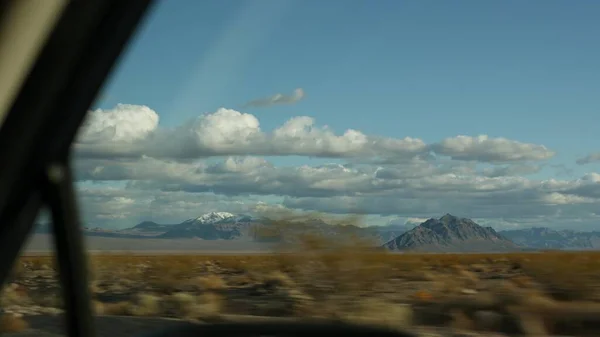 Viaje por carretera, conduciendo auto desde Death Valley a Las Vegas, Nevada, EE.UU. Hacer autostop viajando por América. Viaje por carretera, atmósfera dramática, nube, montaña y desierto de Mojave. Vista desde el coche —  Fotos de Stock