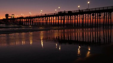 İskele silueti Oceanside California USA. Okyanus gelgiti tropik plaj. Yaz zamanı parlayan atmosfer.