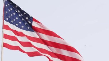 Amerikan bayrağı rüzgarda dalgalanıyor, ABD. Bayrak direğinde Ulusal Sembol Dalgaları.