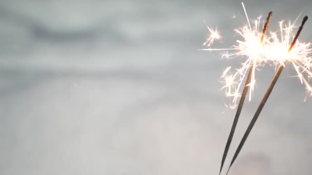 Fuegos artificiales chispeantes ardiendo en la nieve, luces de bengala de Navidad de Año Nuevo. Copos de nieve. — Vídeos de Stock