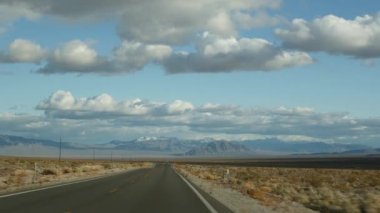 Ölüm Vadisi 'nden Las Vegas, Nevada' ya arabayla yolculuk. Amerika 'da otostop çekmek. Otoyol yolculuğu, dramatik atmosfer, bulut, dağ ve Mojave çölleri. Arabadan görüntüle