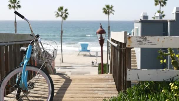 Bicicleta de crucero en bicicleta por la playa del océano, costa de California EE.UU.. Ciclo de verano, escaleras y palmeras. — Vídeos de Stock
