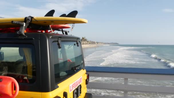 黄色のライフガード車、海のビーチカリフォルニアUSA 。救助トラック、ライフセーバー車を拾う. — ストック動画