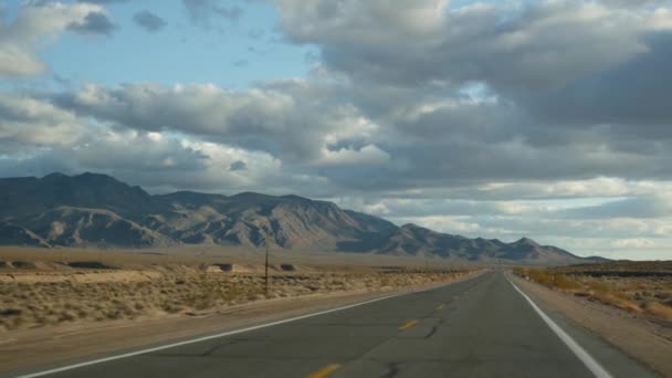 Road trip, auto rijden van Death Valley naar Las Vegas, Nevada USA. Liften op reis in Amerika. Highway reis, dramatische sfeer, wolk, berg en Mojave woestijn wildernis. Zicht vanuit auto — Stockvideo